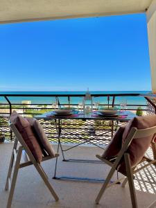 una mesa y sillas en un balcón con vistas al océano en Puerta al Mediterráneo, en Jávea