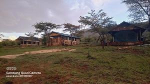 a house in the middle of a field at Sonkoi Tent Safari Camp in Narok