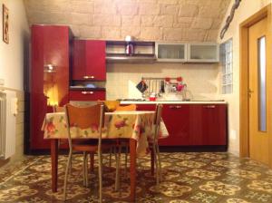 a kitchen with a table with chairs and red cabinets at Sea Home in Monopoli