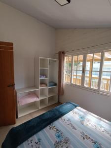 a bedroom with a large bed and a window at Apartamentos Lagoinha in Bombinhas