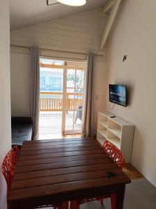 - une salle à manger avec une table et des chaises en bois dans l'établissement Apartamentos Lagoinha, à Bombinhas