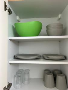 a green bowl and plates on shelves in a kitchen at Vallendarer Stübchen in Vallendar