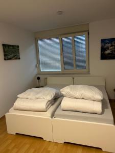 a white bed in a room with two pillows on it at Vallendarer Stübchen in Vallendar