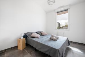 a bedroom with a bed with two pillows on it at Les terrasses - T3 Spacieux avec parking gratuit in Toulouse