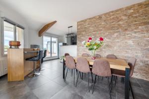 une salle à manger avec un mur en briques, une table et des chaises dans l'établissement Les terrasses - T3 Spacieux avec parking gratuit, à Toulouse