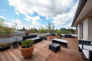 a rooftop deck with chairs and tables on a building at Les terrasses - T3 Spacieux avec parking gratuit in Toulouse