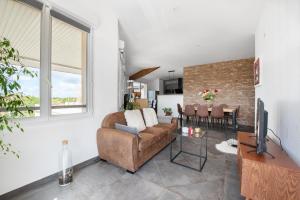 a living room with a couch and a television at Les terrasses - T3 Spacieux avec parking gratuit in Toulouse