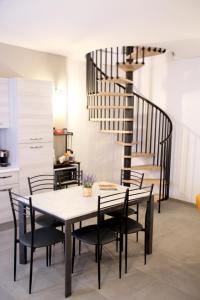 uma sala de jantar com uma mesa e cadeiras e uma escada em espiral em Giolo House em Loreto