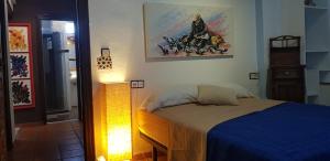 a bedroom with a bed with a blue comforter at La Casa del Pintor - Estudio de Arte en Baeza in Baeza