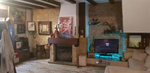 sala de estar con chimenea y TV en La Joya de Baeza: Studio Garrido: Vivienda con Historia y Arte en el Corazón de la Ciudad Patrimonio de la Humanidad, en Baeza