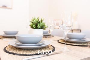 a table with plates and wine glasses on it at Charming 2-bed Home in Nottingham by Renzo, Driveway Parking! in Nottingham