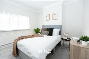 a bedroom with a bed with white sheets and a window at Charming 2-bed Home in Nottingham by Renzo, Driveway Parking! in Nottingham