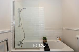 a bathroom with a bath tub with a shower at Charming 2-bed Home in Nottingham by Renzo, Driveway Parking! in Nottingham