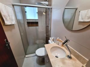 a bathroom with a shower and a sink and a mirror at Casa Gómez in São Lourenço