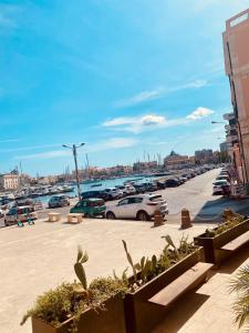 a parking lot with cars parked next to a harbor at Lakkios charming suites and rooms in Siracusa