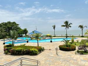 un complejo con una piscina con palmeras y el océano en HOTEL RESORT RIO POTY en São Luís