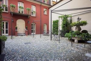 a courtyard of a building with chairs and plants at Porta Palace Apartments in Turin