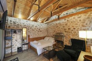 Stonehouse Grace في يوانينا: غرفة نوم بسرير واريكة وطاولة