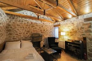 a bedroom with a bed and a desk and a chair at Stonehouse Grace in Ioannina