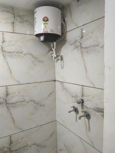 a bathroom with a shower with white marble walls at Star villa hotel in Ujjain