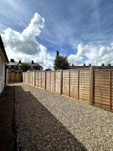 a fence in front of a house with a sky at Seaside Snug - Gorgeous 2 Bed Seaside Bungalow in Hornsea