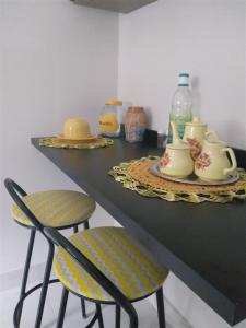 een aanrecht met twee stoelen en een tafel met bekers en flessen bij Casa Gómez in São Lourenço