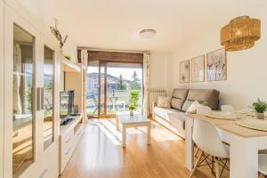 un soggiorno con un divano e un tavolo di Penthouse Pyrinees , Terrace , Parking & Storage a Sabiñánigo