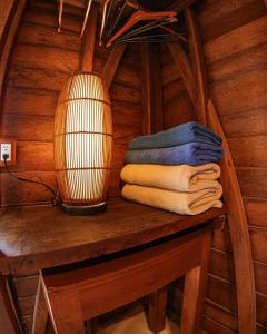 Habitación con mesa, lámpara y toallas en Cabañas Coconut by MIJ, en Isla Holbox