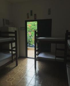 a room with bunk beds and a door to a yard at Alma de Maré Hostel in Guarujá