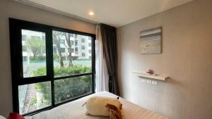 a bedroom with a bed and a large window at The base Central Pattaya by Numam 38 in Pattaya