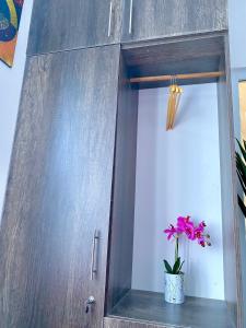 a potted pink flower in a pot in a cabinet at Pilipili Kijani Luxury Homes in Mombasa