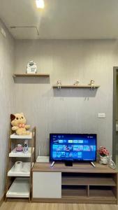 a room with a tv on a table with a shelf at The base Central Pattaya by Numam 38 in Pattaya