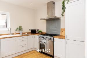 cocina con armarios blancos y fogones en Inviting 3-bed Home in Nottingham by Renzo, Victorian Features, Sleeps 6! en Nottingham