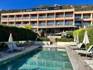 um hotel com piscina em frente a um edifício em Hôtel La Pinède em Ajaccio