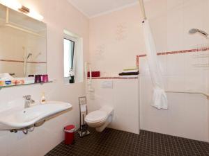 a white bathroom with a sink and a toilet at Pension am Hasenberg in Markische Heide