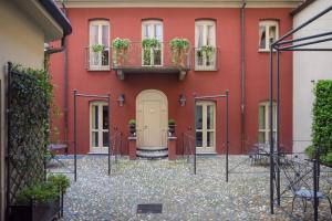 a red building with a door and potted plants at Porta Palace Apartments in Turin