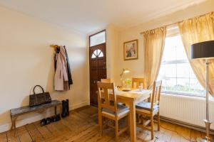 comedor con mesa, sillas y ventana en Maidenhead House Serviced Accommodation in quiet residential area, free parking, 3 bedrooms, WiFi 1 Gbps, work desks, office chairs, TV 55" Roku, Company stays, couples and families welcome, sleeps 6 en Maidenhead