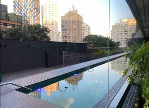 une piscine au milieu d'une ville avec des bâtiments dans l'établissement Estudio alto padrão Oscar Freire, à São Paulo