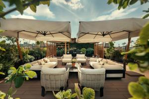 a patio with white furniture and umbrellas at Bulgari Hotel Milano in Milan