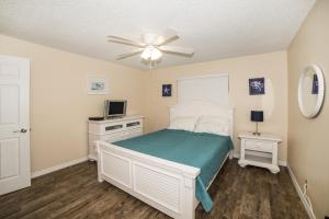 a bedroom with a bed and a ceiling fan at Tropical Indian Rocks Beach suite B in Clearwater Beach