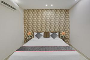 ein Schlafzimmer mit einem Bett und einer Wand in der Unterkunft Collection O Hotel The Telone stay in Gurgaon