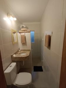 a white bathroom with a toilet and a sink at Apartamentos Lagoinha in Bombinhas +37 photos