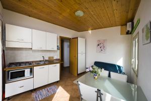 a kitchen with white cabinets and a wooden ceiling at Appartamento sul mare in Castellammare del Golfo