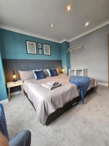 a bedroom with a large bed with blue walls at Leyland House, 3 Bedroom, Parking Space, Coventry CV5 in Allesley