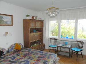 a bedroom with a bed and chairs and a table at Tulipán Panoráma Apartman in Pécs