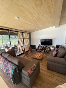 ein Wohnzimmer mit Sofa und Fernseher in der Unterkunft Colores de Manantiales in Villa General Belgrano