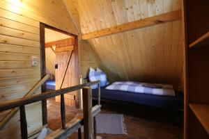 pokój z łóżkiem w drewnianym domku w obiekcie Ferienhaus Anno Dazumal, wie zu Großmutters Zeiten w mieście Klingenthal