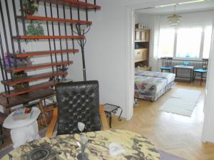 ein Wohnzimmer mit einem Tisch und einer Wendeltreppe in der Unterkunft Tulipán Panoráma Apartman in Pécs