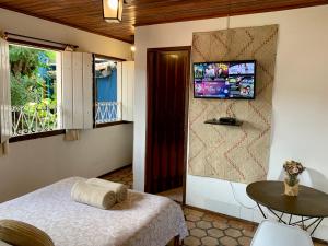 Hospedaria Tayrona في لينكويس: غرفة نوم مع سرير وتلفزيون على الحائط