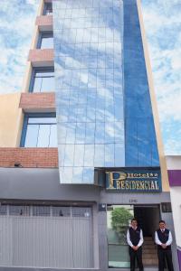 Hotel Presidencial في تشيكلايو: رجلان يقفان في مدخل المبنى